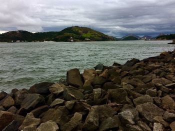 Rocks by sea against sky