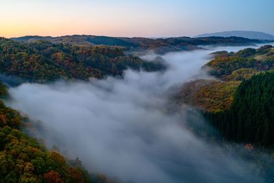 Scenic view of waterfall against sky during sunset