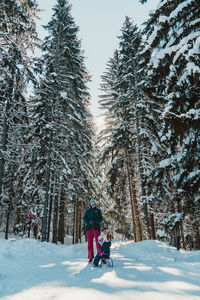 Mother and daughter on snow covered mountain