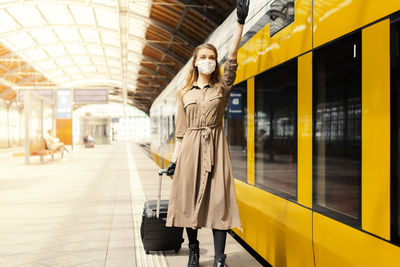 Portrait of woman standing on train at railroad station