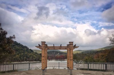 View of gate against cloudy sky