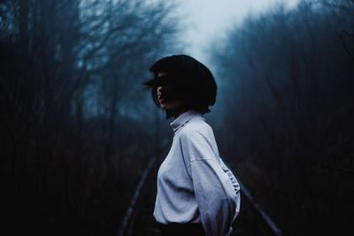 Young woman standing on footpath during foggy weather