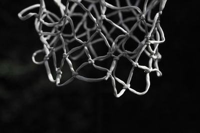 Close-up of basketball hoop against black background
