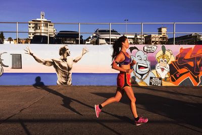 Woman with umbrella against sky in city