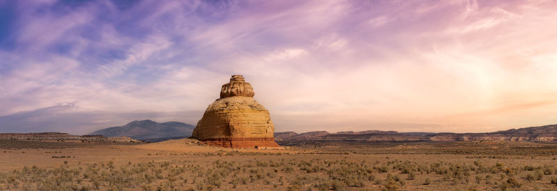 Rock formations on landscape against sky during sunset