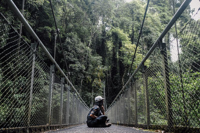 Rear view of man walking on footbridge