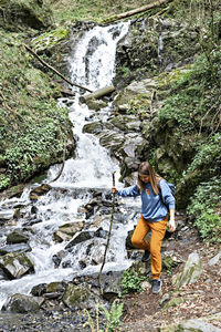 Full length of man standing on rock in forest