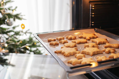 Baking tray with ginger christmas cookies snowflakes in the oven. christmas kitchen interior.