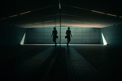 Rear view of people walking on illuminated staircase