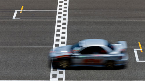 Race car blurred motion crossing the finish line on international circuit speed track, motion blur.