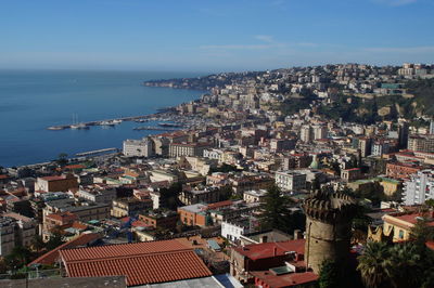 High angle view of townscape by sea against sky