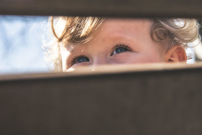 Baby eyes seen through wooden fence