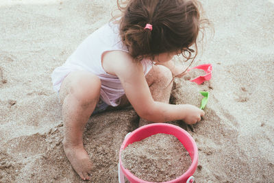 High angle view of girl playing on sand