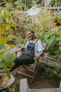 Portrait of female farmer sitting on chair in organic farm