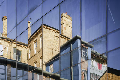 Reflections of old buildings in the windows of a modern building