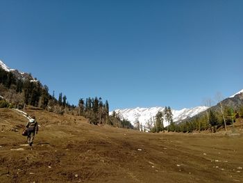 Man riding motorcycle on snowcapped mountain against sky