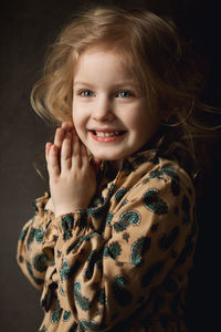 Portrait of smiling girl against black background