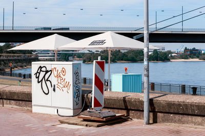 Graffiti on bridge over river against sky