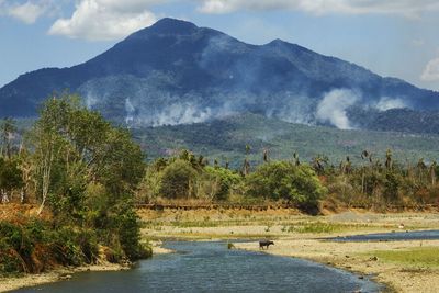 Scenic view of lake in front of mountains against sky