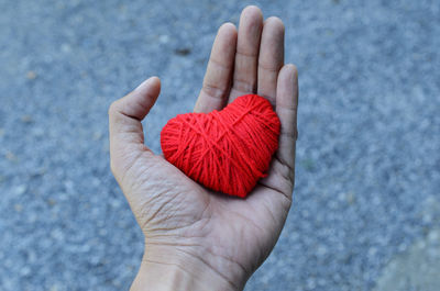 Cropped hand holding heart shape wool