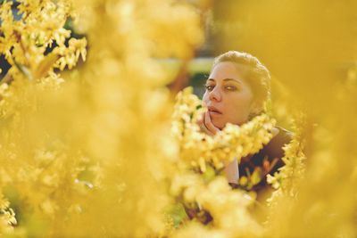 Portrait of woman amidst yellow flowers