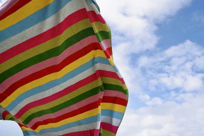 Low angle view of multi colored flag against sky