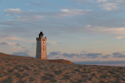 Lighthouse by sea against sky