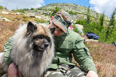 Man hugs his beloved dog while walking in the mountains