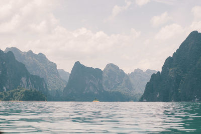 Scenic view of sea and mountains against sky