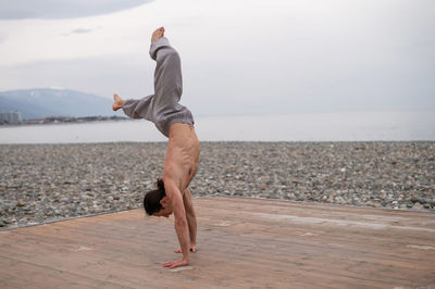 Man doing handstand at beach