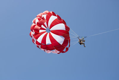 Low angle view of red flag against clear blue sky