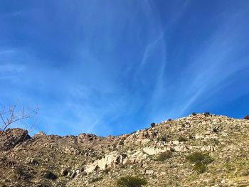 Low angle view of rocks against blue sky