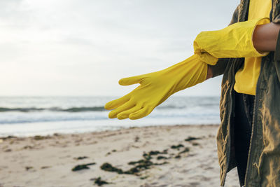 Woman standing on beach against sky