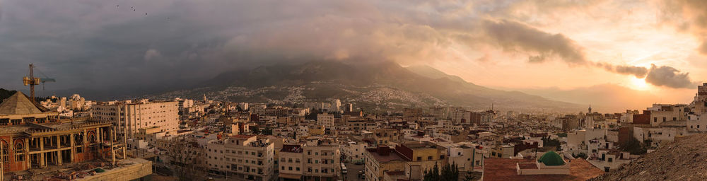 Panoramic view of cityscape against cloudy sky