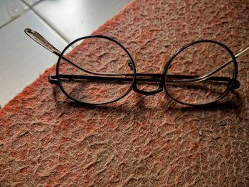 Close-up of eyeglasses on table against wall