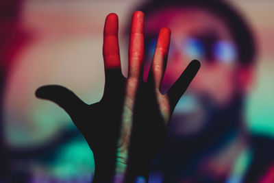 Cropped hand against illuminated background