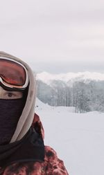 Rear view of woman in snowboard clothes standing on snow covered landscape