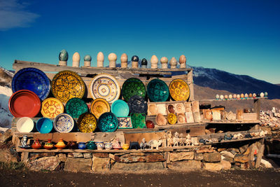 Various ceramics for sale at market against mountain