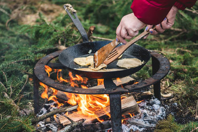 Cooking blini, blin or blynai, pancakes traditional sweet food, preparing outdoor on an open fire