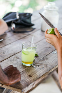 Cropped image of hand holding drink on table