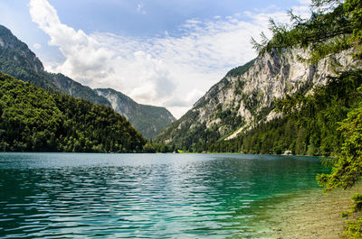 Scenic view of lake by mountains against sky