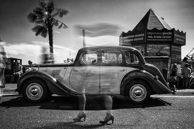 Cars on road against cloudy sky