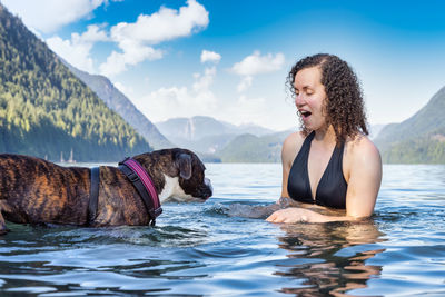 Young woman with dog in the water