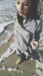 High angle view of woman holding monopod while walking on shore