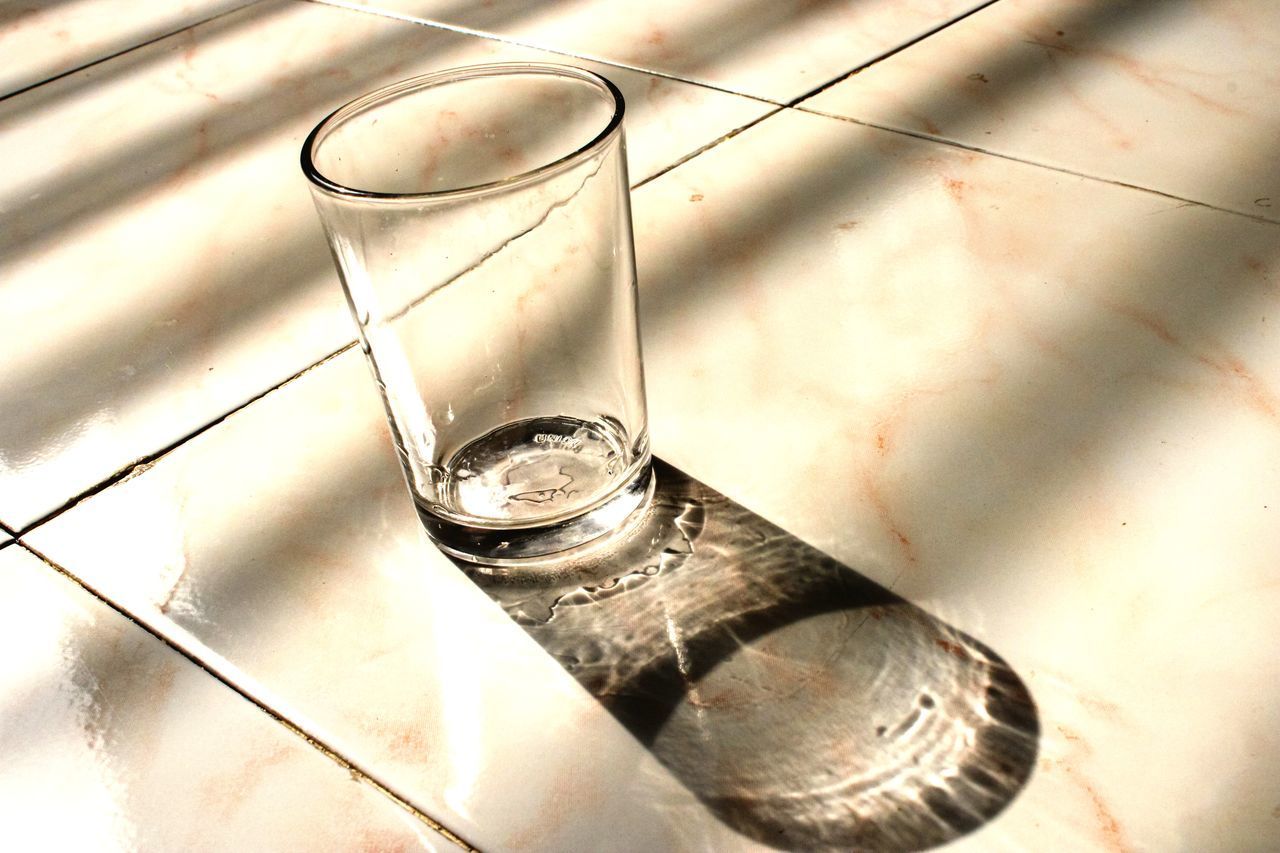 HIGH ANGLE VIEW OF WATER ON GLASS TABLE