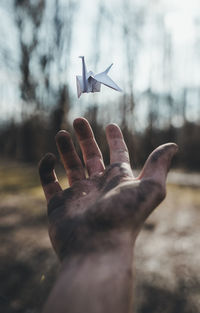 Cropped image of messy hand with origami