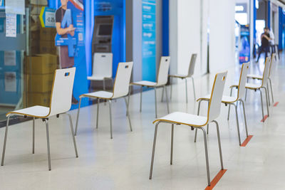 Group of empty chairs arranged for social distancing in front of bank. 