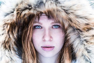 Close-up portrait of young woman in fur coat