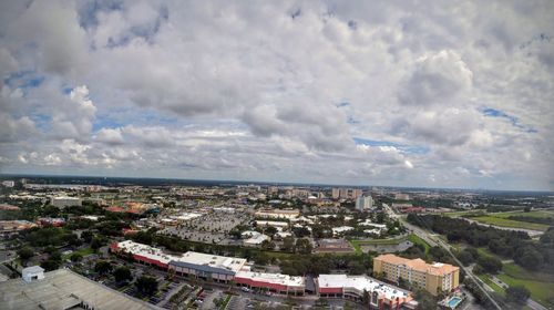 Aerial view of cityscape against cloudy sky