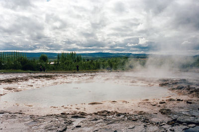 Scenic view of geyser against sky